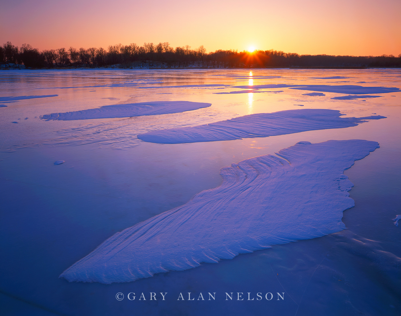 Setting sun over wind sculptured snow on Henchien Lake, Sibley State Park, Minnesota