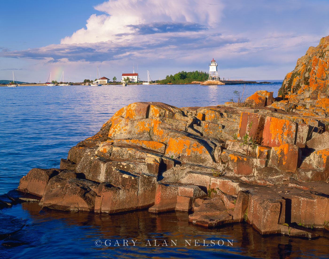 MN-04-77-LH Lichen encrusted rocks, rainbow and Grand Marias Light Station along Lake Superior, Grand Marais, Minnesota