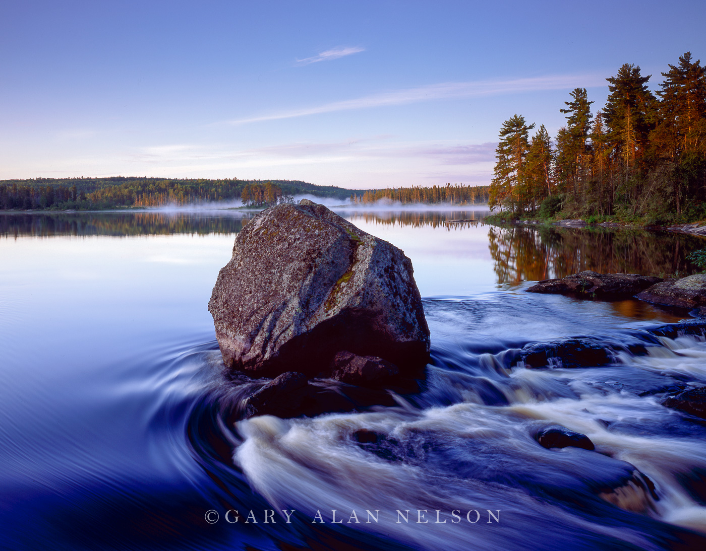 Boulder and the Basswood River at dawn, Booundary Waters Canoe Area Wilderness, Minnnesota There is a coveted campsite at the...